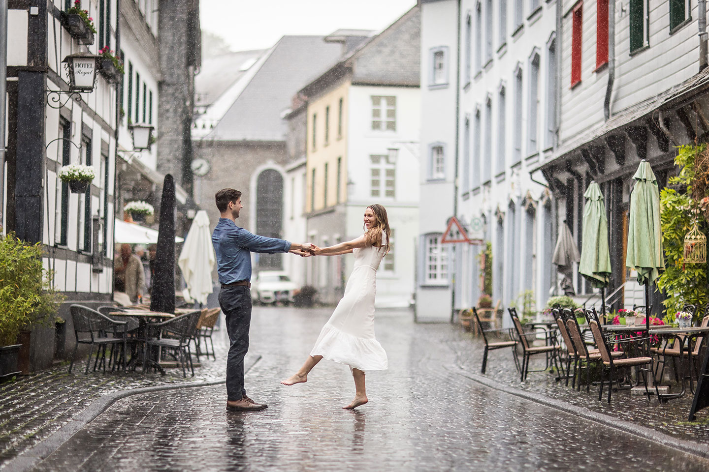 Couple dancing in the rain during their engagement shoot in Monschau, Germany